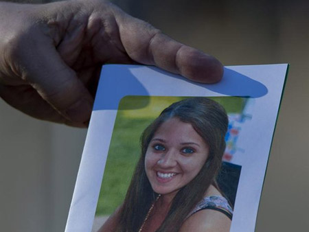 Una persona sostiene una tarjeta con un retrato de la profesora Victoria Soto en la iglesia cristiana Comunidad del Señor de Stratford