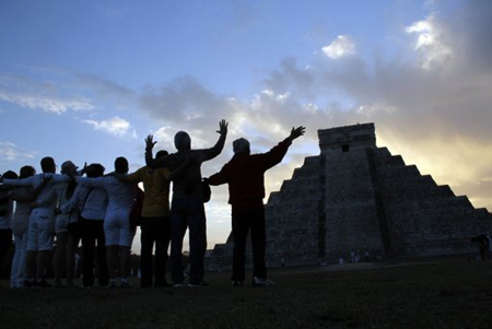 Un grupo de personas extiende sus brazos frente al templo de Kukulkán en Chichén Itzá, México, el viernes 21 de diciembre de 2012.