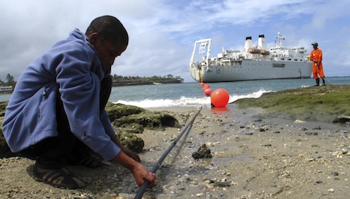 Kenyan boy looks at TEAMS fiber optic cable from the ship Niwa on the Fort Jesus shore-end in the coastal city of Mombasa