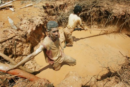 Unlicensed Venezuelan miner uses water jet to hose down earth as he hunts for gold near Las Cristinas concession