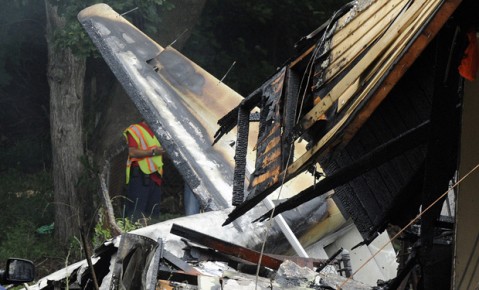 A responder surveys the scene of a small plane crash, Friday, Aug.