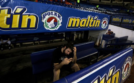 Foto del 27 de noviember de 2013 que muestra al pitcher de los Tiburones de La Guaira Ryan Kussmaul hablando por teléfono antes de un juego contra los Leones en el Estadio Universitario in Caracas, Venezuela. (Foto de AP/Fernando Llano)