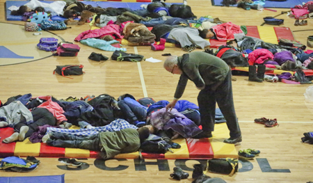  Un profesor cubre con cobijas a estudiantes de la escuela "E. River", quienes tuvieron que pasar la noche en el gimnasio de la institución 