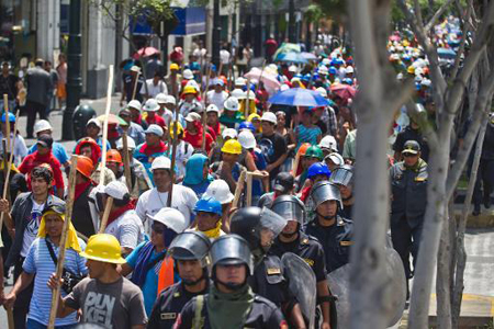  Mineros informales en una protesta en el centro de Lima son escoltados por policías de choque, el 25 de marzo de 2014 AFP / ERNESTO BENAVIDES 