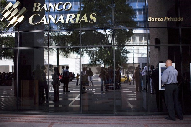 A bank customer tries to use an ATM of Banco Canarias in Caracas