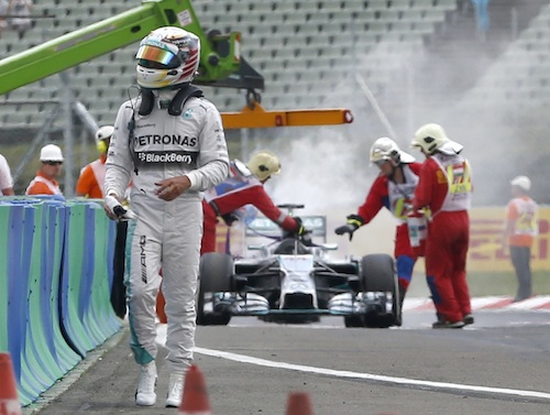 Hamilton sale frustrado de su Mercedes, el cual se observa el fondo cuando los asistentes de pistas sofocan el fuego. Foto: AP