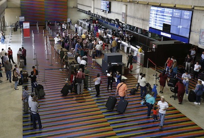 Passengers walk at the Simon Bolivar airport in La Guaira