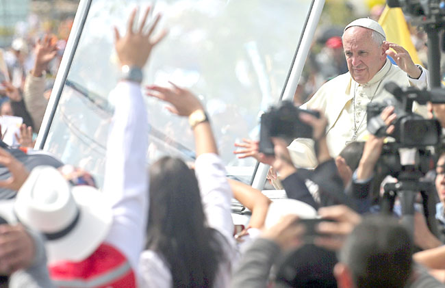 Pope Francis waves as he arrives to celebrate Mass at Bicentennial Park in Quito, Ecuador, Tuesday, July 7, 2015. Pope Francis kicked off his final full day in Ecuador on Tuesday with an open-air Mass in the capital. (AP Photo/Fernando Llano)