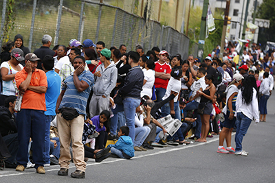 People line up outside a state-run Bicentenario supermarket in Caracas January 9, 2015. Lines swelled at Venezuelan supermarkets on Friday with shoppers queuing up by the hundreds to seek products ranging from chicken to laundry detergent, as a holiday slowdown in deliveries sharpened the OPEC nation's nagging product shortages. Queues snaked around the block at grocery stores and pharmacies around the country, with consumers in some cases gathering before dawn under the gaze of national guard troops posted to maintain order. REUTERS/Jorge Silva (VENEZUELA - Tags: POLITICS BUSINESS)