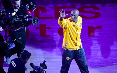 Kobe Bryant gestures to fans as he takes the court for his last game for the Los Angeles Lakers against Utah Jazz in their season-ending NBA western division matchup n Los Angeles, California on April 13, 2016. / AFP PHOTO / FREDERIC J. BROWN