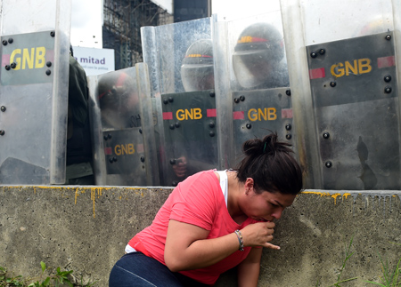 Una mujer muestra evidentes síntomas de afectación a causa de gas lacrimógeno lanzado por efectivos de la PBN. AFP / RONALDO SCHEMIDT 