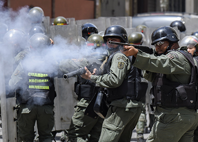 Security forces clash with people trying to reach Miraflores presidential palace to protest against the severe food and medicine shortages, in Caracas on June 2, 2016. Venezuelans face long lines at supermarkets tightly guarded by nervous soldiers, bare shelves and soaring prices inside, a dysfunctional health care system short on basic medications and supplies, daily power cuts of four hours across most of the country, and a government that only operates two days a week to save electricity. / AFP PHOTO / JUAN BARRETO