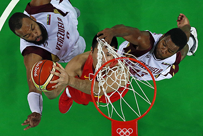 An overview shows (From L) Venezuela's centre Gregory Echenique, China's forward Zou Yuchen and Venezuela's power forward Nestor Colmenares go for a rebound during a Men's round Group A basketball match between Venezuela and China at the Carioca Arena 1 in Rio de Janeiro on August 10, 2016 during the Rio 2016 Olympic Games. / AFP PHOTO / POOL / Jim YOUNG