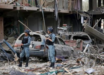 Afghan policemen stand guard at the site of a suicide truck bomb in Kabul, Afghanistan