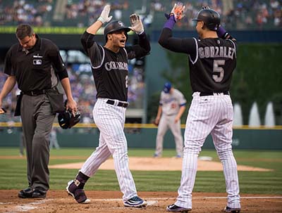 DENVER, CO - AUGUST 3: Nolan Arenado #28 of the Colorado Rockies celebrates with Carlos Gonzalez #5 after hitting a first inning 3-run homerun off of Brock Stewart #51 of the Los Angeles Dodgers during a game at Coors Field on August 3, 2016 in Denver, Colorado.   Dustin Bradford/Getty Images/AFP