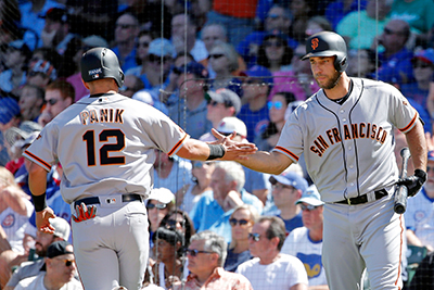 CHICAGO, IL - SEPTEMBER 03: Joe Panik #12 of the San Francisco Giants is congratulated by Madison Bumgarner #40 (R) after scoring on an RBI single by Eduardo Nunez #10 (not pictured) during the fourth inning at Wrigley Field on September 3, 2016 in Chicago, Illinois.   Jon Durr/Getty Images/AFP