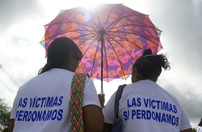 Colombian victims of the conflict march before  an act of atonement by Revolutionary Armed Forces of Colombia (FARC) leaders Ivan Marquez  and Pastor Alape (not framed) in  Apartado, Antioquia department, Colombia on September 30, 2016.  On January 23, 1994, a group of FARC guerrillas, stormed into La Chinita neighborhood, shooting indiscriminately and killing 35 people in which was one of the first massacres committed by the FARC. / AFP PHOTO / RAUL ARBOLEDA