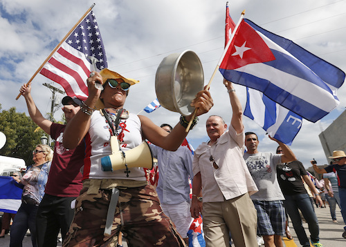 Banging pots and pans and waving Cuban and American flags, members of the Cuban community react to the death of Fidel Castro, Saturday, Nov. 26, 2016, in the Little Havana area in Miami. Castro, who led a rebel army to improbable victory in Cuba, embraced Soviet-style communism and defied the power of 10 U.S. presidents during his half century rule, died at age 90. (AP Photo/Wilfredo Lee)