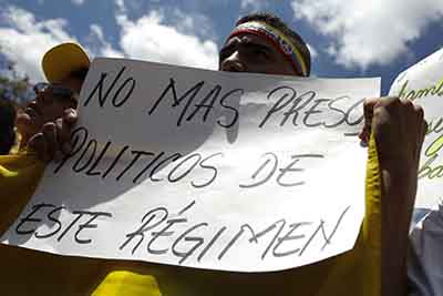 A supporter of arrested Caracas metropolitan mayor Antonio Ledezma holds a banner that reads "No more political prisioners in this regime" during a gathering in support of him in Caracas February 20, 2015. Venezuelan opposition leaders on Friday demanded the release of a veteran Caracas mayor arrested on accusations of plotting violence against President Nicolas Maduro's government. REUTERS/Carlos Garcia Rawlins (VENEZUELA - Tags: POLITICS)