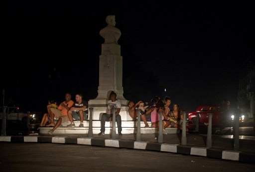 Cubanos se sientan alrededor de una plaza con los faros de automóviles durante un apagón en La Habana el 9 de septiembre de 2012. Unas seis provincias del país sufrieron el apagón. Foto: AFP