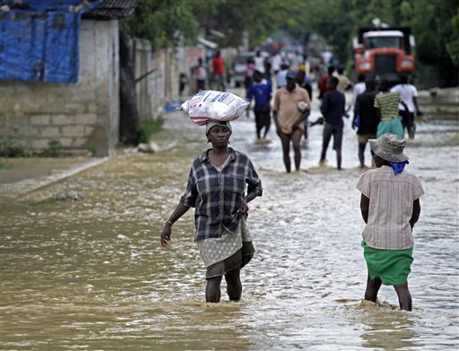 Unas personas caminan por calles inundadas por el huracán Sandy, en La Plaine, Haití.