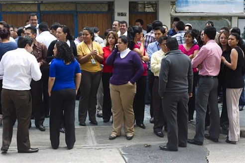 Varias personas hablan después de ser evacuadas de un edificio hoy, tras que un sismo de 7,5 en la escala abierta de Richter sacudiera Guatemala. (Foto EFE /Saúl Martínez)