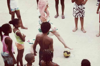 En la favela jugó fútbol descalza y cantó su tema "Born this way" con decenas de niños