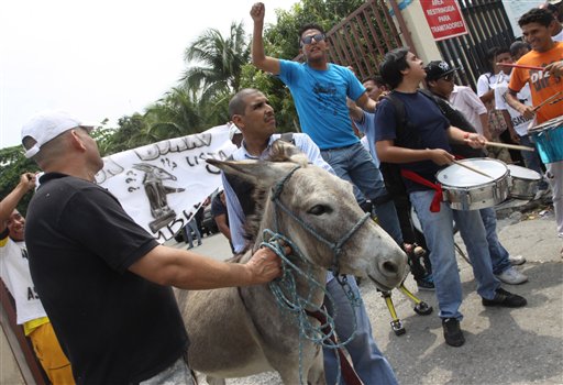 Varias personas acompañan al burro denominado "Don Burro" a las afueras del Consejo Provincial Electoral en Guayaquil, Ecuador, el jueves, 15 de noviembre de 2012. Las personas querían inscribir al burro como candidato a la asamblea nacional, pero su solicitud fue rechazada.