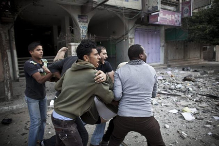 Unos palestinos atienden a un hombre herido durante el bombardeo israelí a las oficinas de Hamas TV en la Ciudad de Gaza, Franja de Gaza, el lunes 19 de noviembre de 2012.