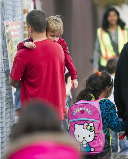 Tom Fico abraza a su hijo Lucas, de 5 años, mientras dejan a su hermano mayor Jake (fuera de cuadro) en la escuela Theodore Roosevelt en Burbank, California, el lunes 17 de diciembre de 2012.