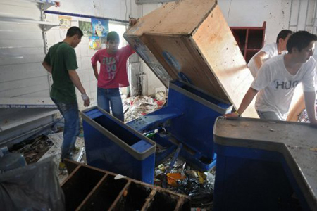 Empleados de un supermercado de San Fernando, en la provincia de Buenos Aires, organizan el mobiliario tras un saqueo.