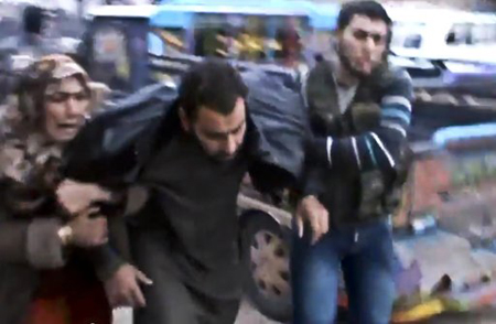Esta imagen del domingo 23 de diciembre de 2012, tomada de un video obtenido por Shaam News Network, de la cual se ha verificado su autenticidad sobre la base de su contenido y otros reportes de AP, muestra a sirios ayudando a un hombre herido tras un ataque aéreo del gobierno en el suburbio de Hama, en Halfaya, Siria.