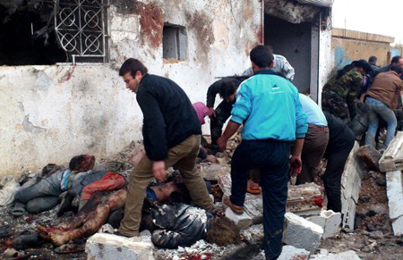 Una imagen tomada por la red de noticias Edlib, autentificada con base a su información y otros reportes de The Associated Press, muestra a un grupo de civiles retirando los cadáveres de la vía pública después de un bombardeo aéreo del gobierno en el suburbio Hama de Halfaya, Siria, el domingo 23 de diciembre de 2012.