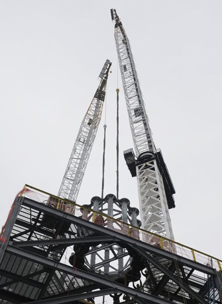 La primera pieza de la aguja del One World Trade Center es colocada por medio de grúas en el techo de la torre