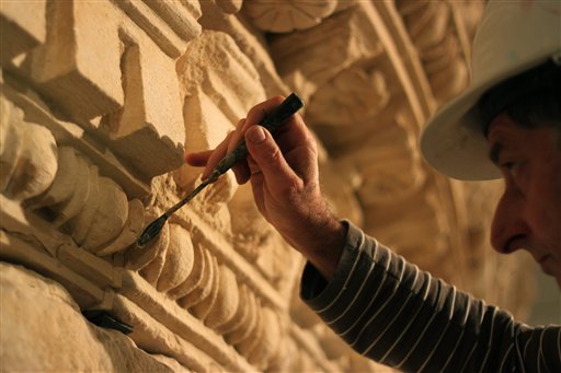 Un restaurador del museo nacional de Israel trabaja en una pieza exhibida que los curadores aseguran fue la tumba de Herodes, en el museo israelí en Jerusalén. (Foto AP/Daniel Estrin)