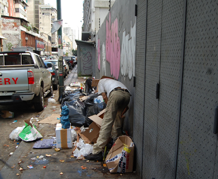 Indigentes hurgan entre la basura que permanece en las calles de La Candelaria.