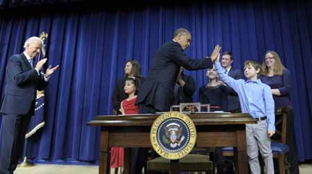 El presidente Barack Obama saluda al estudiante Grant Fritz durante una conferencia de prensa donde anunció un plan para reducir la violencia armada, en la Casa Blanca, el miércoles 16 de enero de 2013.