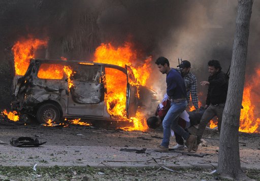 Agentes de seguridad cargan un cuerpo después de una fuerte explosion en el centro de Damasco, Siria, el jueves 21 de febrero de 2013.