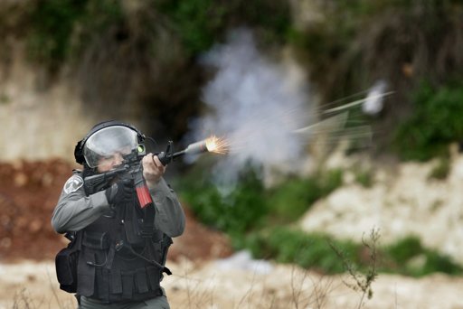 Un policía fronterizo israelí dispara balas de goma durante una manifestación en apoyo de prisioneros palestinos, en las afueras de Ofer, una cárcel militar israelí.