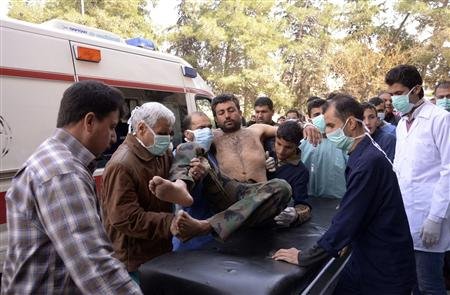 Un grupo de residentes locales y médicos transportan a un soldado, herido en un ataque con presuntas armas químicas, en Aleppo, Siria, el 19 de marzo de 2013.