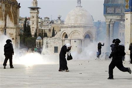 En la imagen del 8 de marzo, una palestina se tapa el rostro tras el estallido de una granada aturdidora en la explanada de las mezquitas.