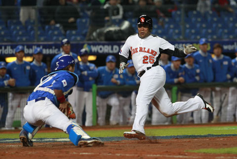 El jugador de Holanda, Andruw Jones, intenta evadir al catcher de Corea del Sur, Kang Minho. Foto: AP/Wally Santana