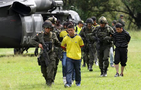 Supuestos guerrilleros de las Fuerzas Armadas Revolucionarias de Colombia son escoltados por policías colombianos en Cali, Colombia, el viernes 26 de abril del 2013.