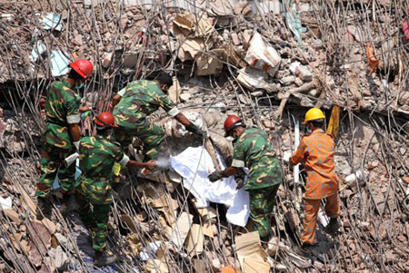 Varios rescatistas laboran para extraer cadáveres en descomposición dentro de los escombros de un edificio con fábricas de ropa que se vino abajo en Savar, cerca de Daca, Bangladesh.