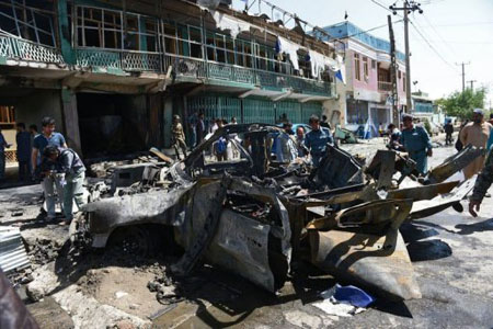 Policías afganos ante un vehículo militar de EEUU destruido por el atentado de este jueves en Kabul.