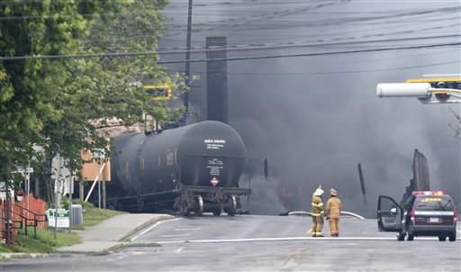 Humo sale de un tren descarrilado que transportaba crudo en el centro de Lac Megantic, en Quebec, Canadá, el sábado 6 de julio del 2013. El descarrilamiento causó la evacuación de hasta 1.000 personas, (Foto AP/The Canadian Press, Paul Chiasson)