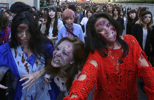 Personas disfrazadas y maquilladas como zombis actúan durante un evento del Día de las Brujas en la Torre de Tokio, el jueves 31 de octubre de 2013. (AP Foto/Shizuo Kambayashi)