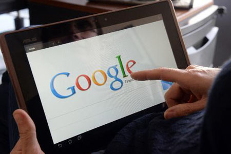 Imagen tomada el 13 de mayo de 2013 en Rennes, Francia, muestra a una mujer señalando el logo de Google.
AFP / DAMIEN MEYER