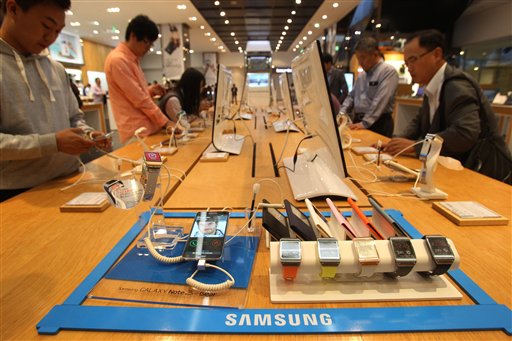 Un Galaxy Note 3, abajo izquierda, y Galaxy Gears, relojes de pulso con pantallas sensibles al tacto, de Samsung, son mostrados en una sala de exhibición de la sede de Samsung Electronics Co. en Seúl, Corea del Sur. Ante la gran anticipación por dispositivos móviles con pantalla flexible, Samsung Electronics informó que estrenará un smartphone con pantalla curvada. (Foto AP/Ahn Young-joon)