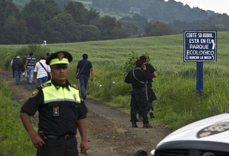  Policías vigilan la zona rural donde se encontró una fosa común con al menos siete cuerpos en un parque a 30 km de Ciudad de México. AFP